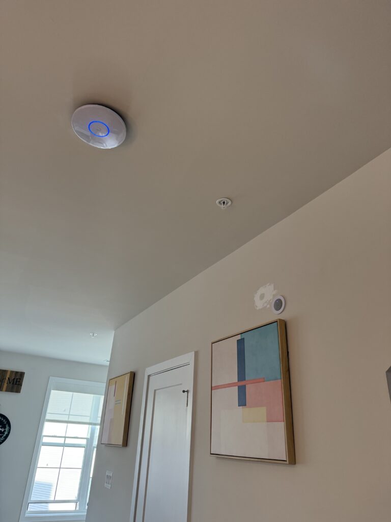Ceiling-mounted wireless access point U6 Pro near a home entryway.